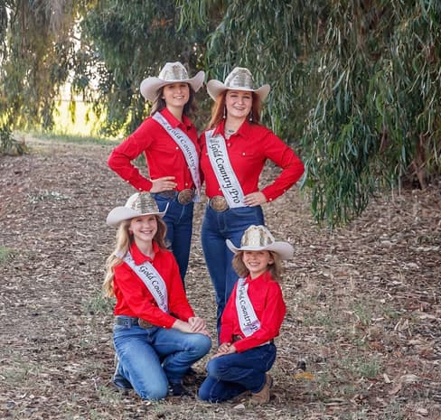 The Gold Country Pro Rodeo royalty court in red shirts, sashes and crowned cowboy hats